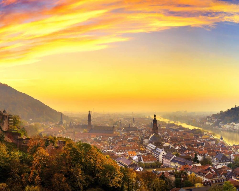Heidelberg, Germany, aerial panoramic view at dusk, with colorful sunset sky, the castle, Neckar river and the Old Bridge